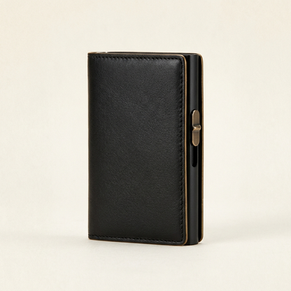 A black leather card holder wallet with a gold-toned clasp, shown standing upright on a light beige background.